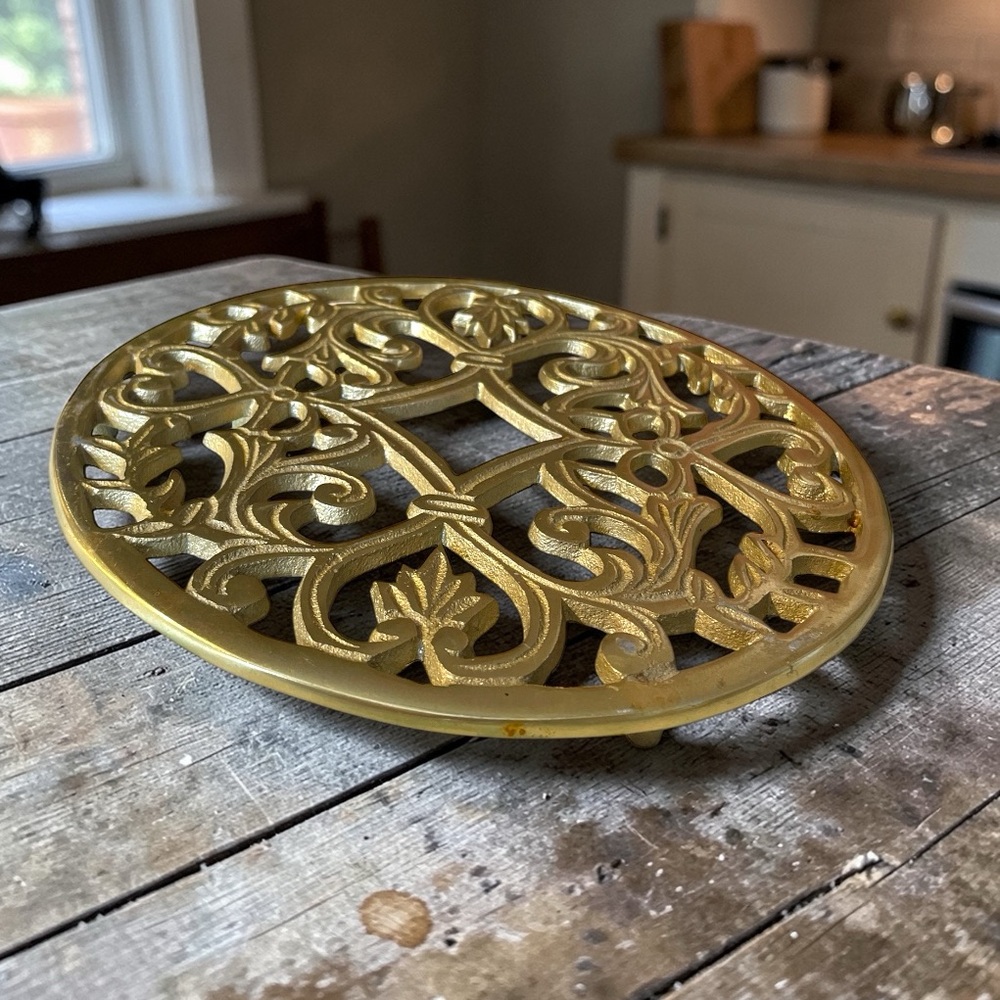 Vintage metal trivet with 3 feet, appears to be painted to look like brass